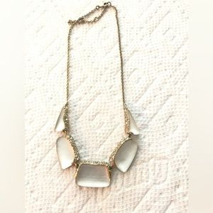 Alexis Bittar white lucite necklace with crystals in gold tone setting.